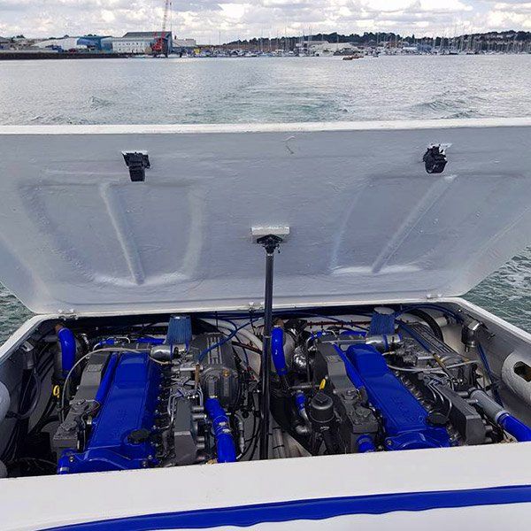 the engine of a boat is shown with the hood open .