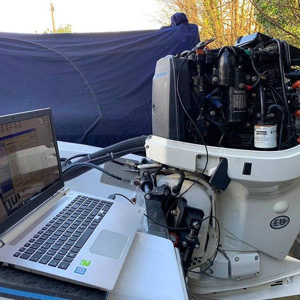 a laptop is sitting on a table next to a boat engine