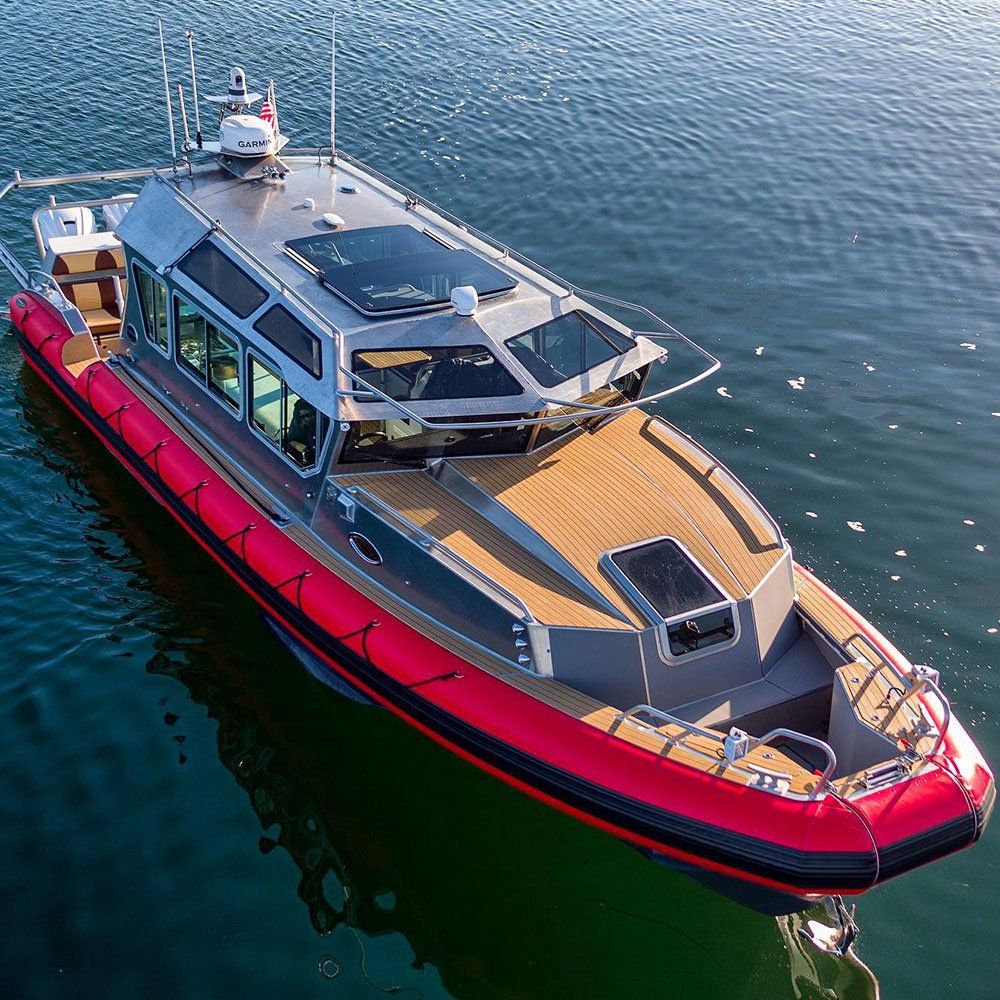 a large red boat is floating on top of a body of water .