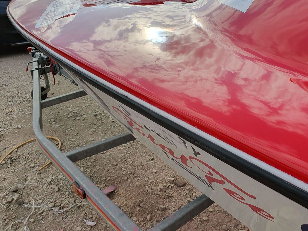 a red and white boat is on a trailer