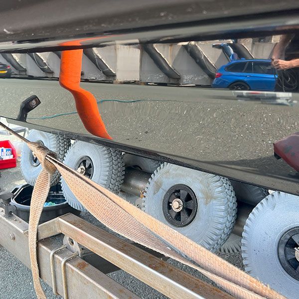 a reflection of a blue car in a mirror on a trailer