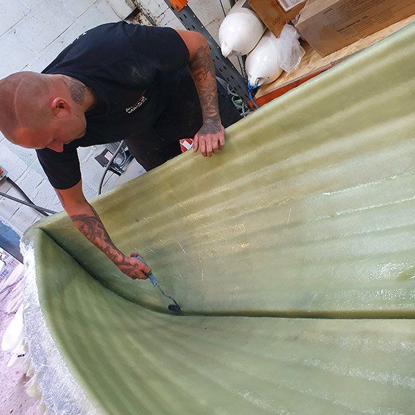 a man in a black shirt is painting a green surface
