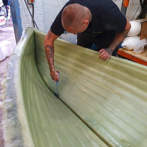a man with a tattoo on his arm is working on a boat