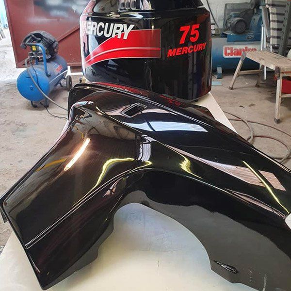 a mercury 75 outboard motor sits on top of a black fender