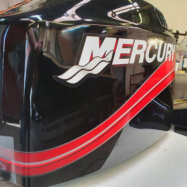 a black and red mercury motor sits on a table