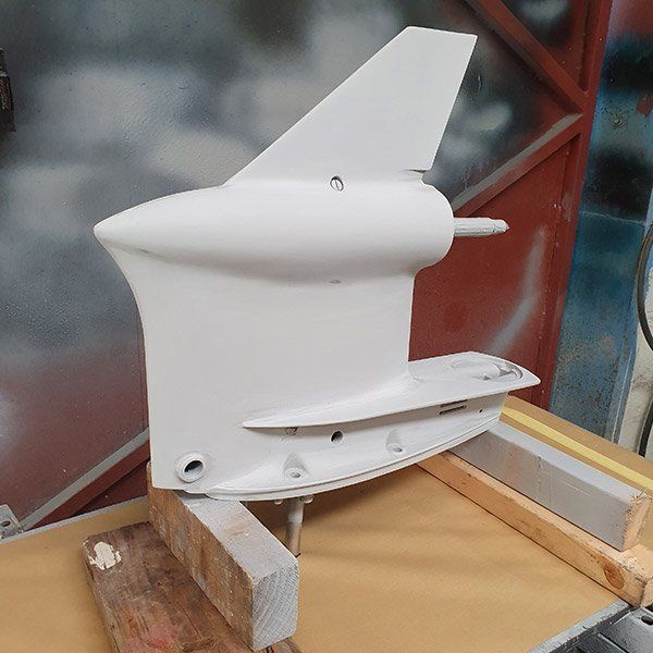 a white model of an airplane is sitting on a wooden table .