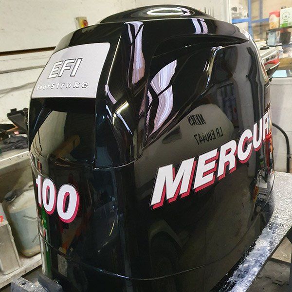 a black mercury outboard motor sits on a table