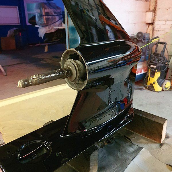 a black boat propeller is sitting on a table in a garage