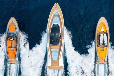 three boats are floating on top of a body of water .