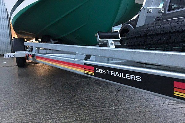 a green boat is sitting on top of a trailer .