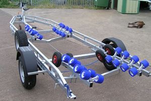 a boat trailer with blue wheels is parked on the side of the road