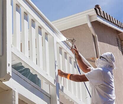 House Painter Spray Painting A Deck of A Home - Exterior Painting in Bozeman, MT