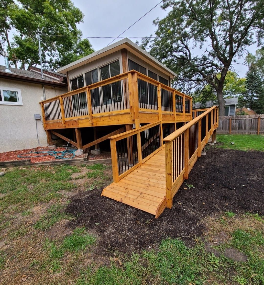 A wooden deck with a ramp leading to it in front of a house.