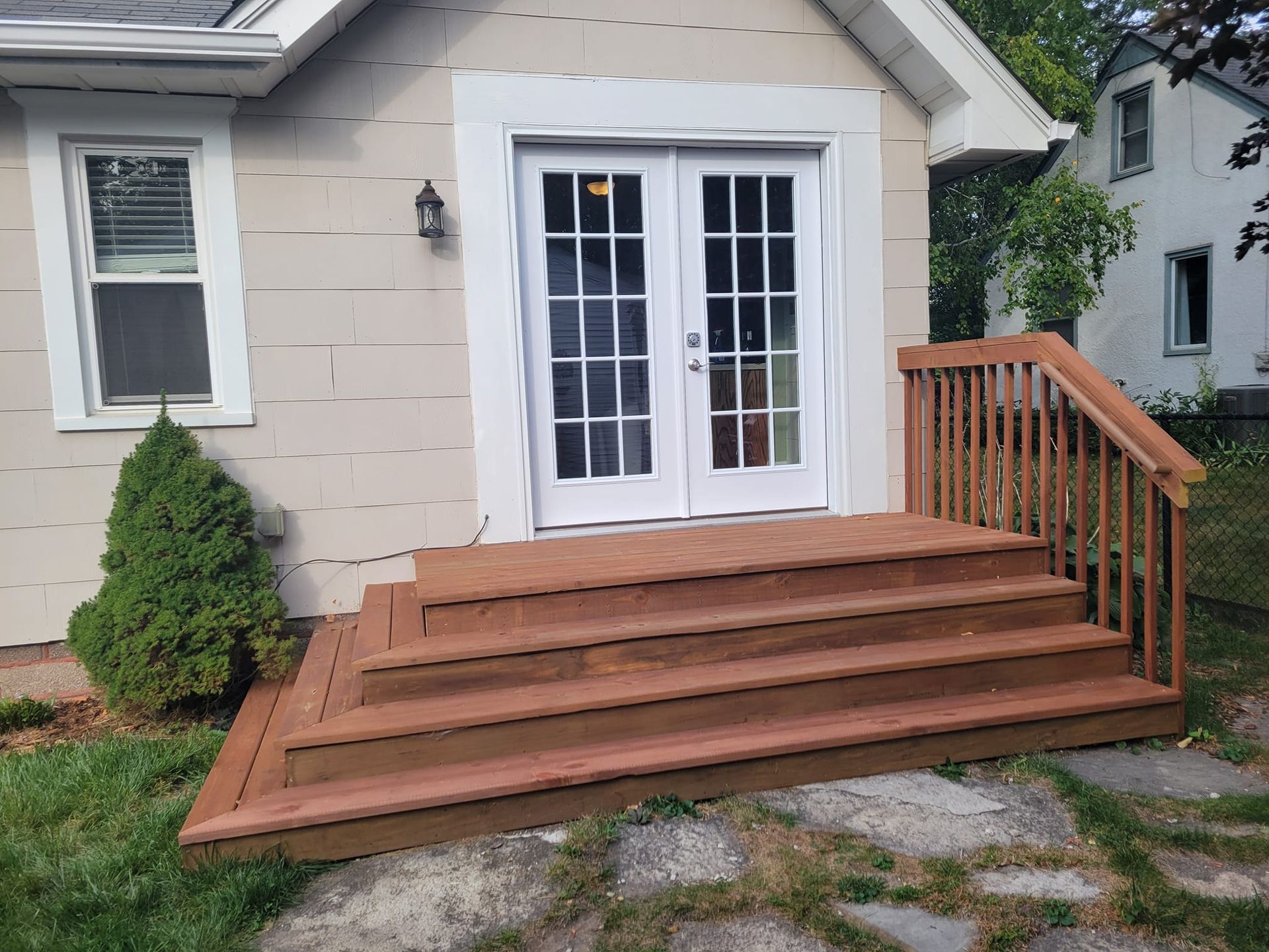 A house with a wooden deck and stairs in front of it