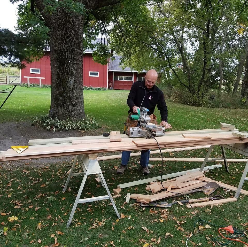 A man is using a circular saw to cut a piece of wood
