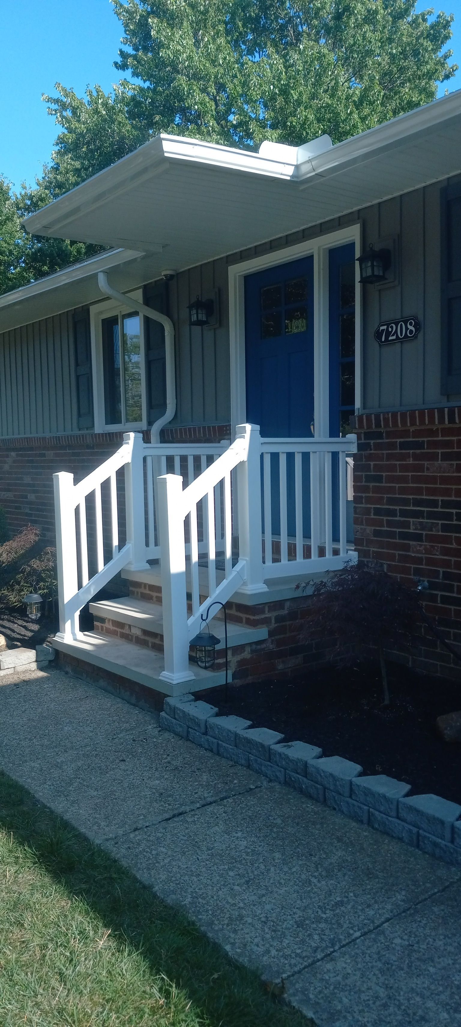 A house with a blue door and a white porch with stairs.