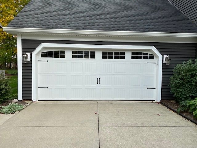 A garage with a white door and a black roof