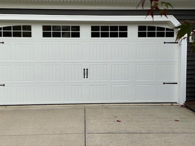 A white garage door with a black trim and windows