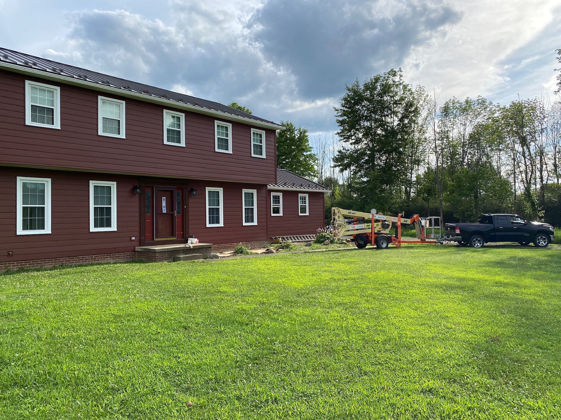 A large red house with a black truck parked in front of it.