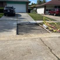 A vehicle drives on a concrete road, next to a construction site.