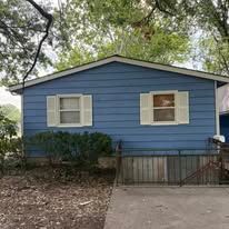 Blue house with white trim, two windows, and a small porch.
