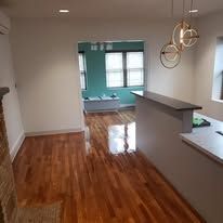 Interior view with hardwood floors, a bar counter, and a doorway to another room.