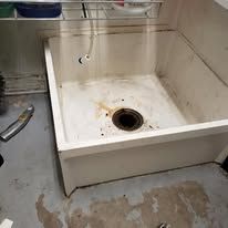 White utility sink with rust stains.