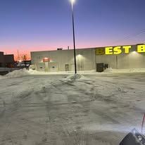 Snowy Best Buy at dusk under a street light.