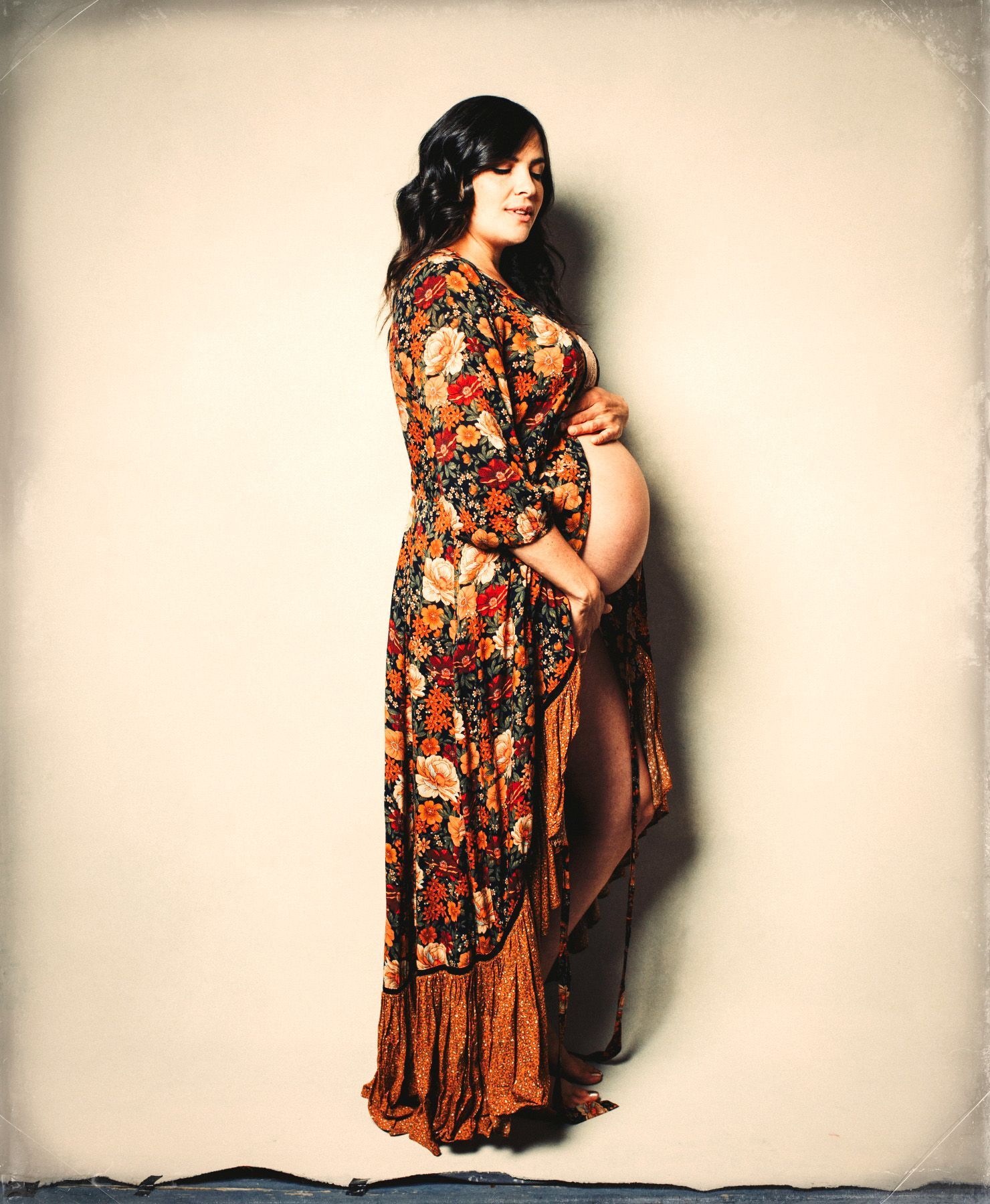 mother posed in maternity gown for pregnancy photo shoot in Asheville