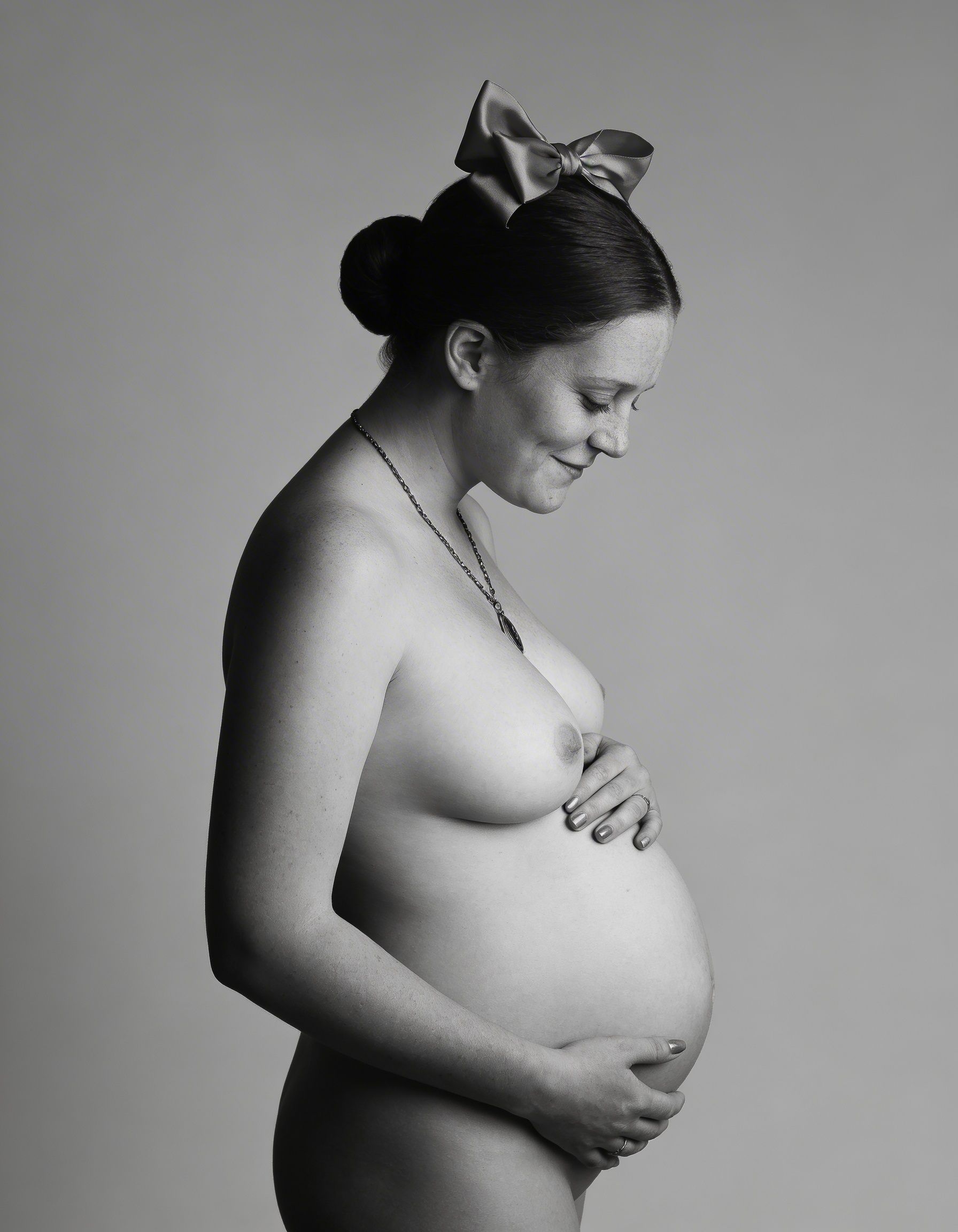 pregnant woman in maternity gown posed in studio 