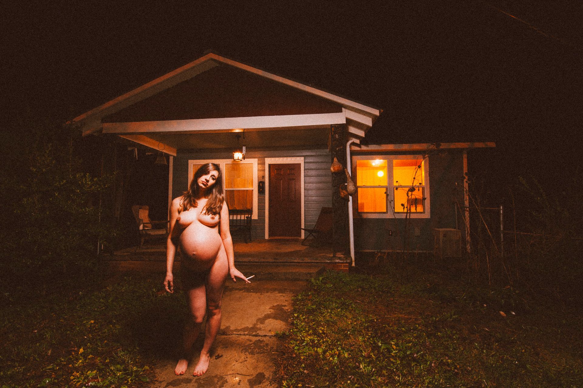 stunning image of bold and confident pregnant woman outside of an Asheville home, 32 weeks