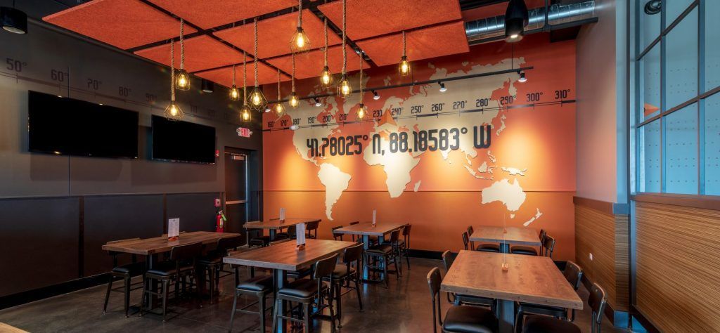 A restaurant with tables and chairs and a map of the world on the wall.