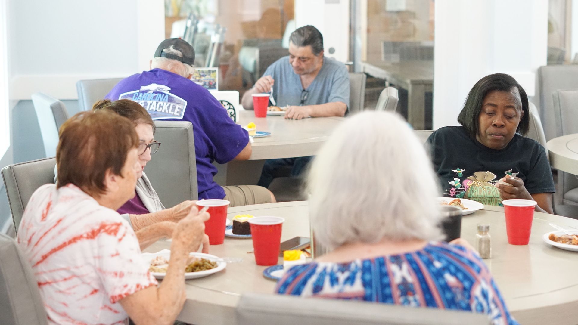 a group of people are sitting at a table eating food .