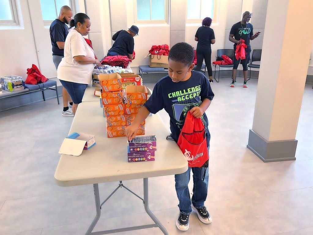 a boy is standing in front of a table with boxes on it .