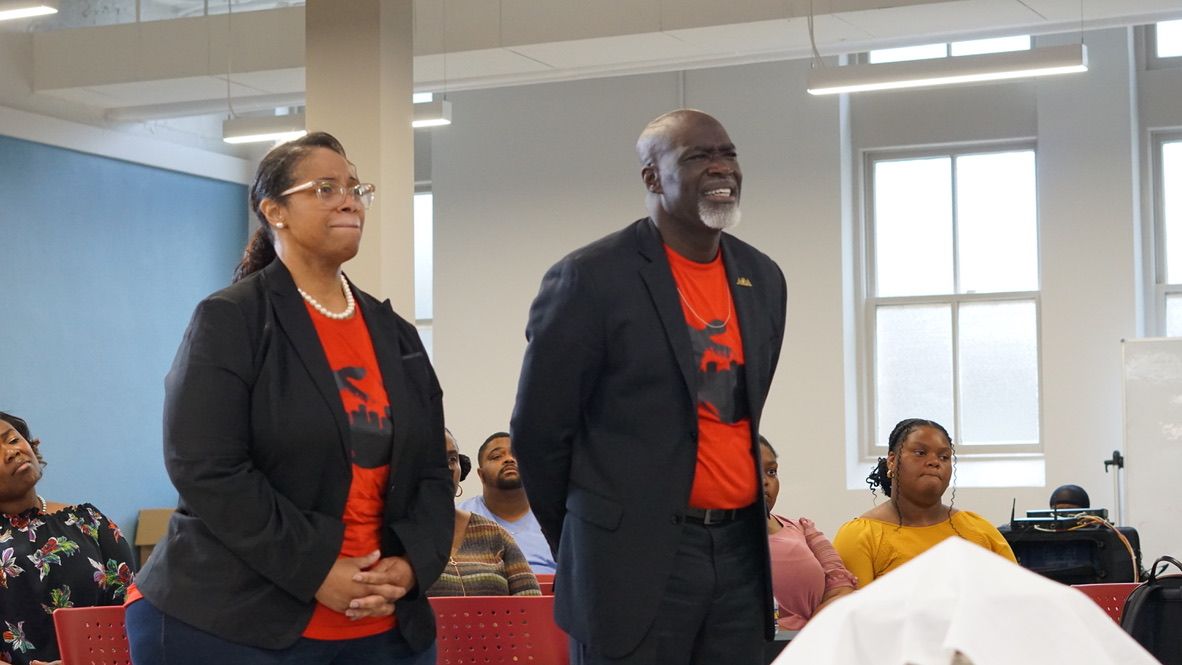 a man and a woman are standing next to each other in a room .
