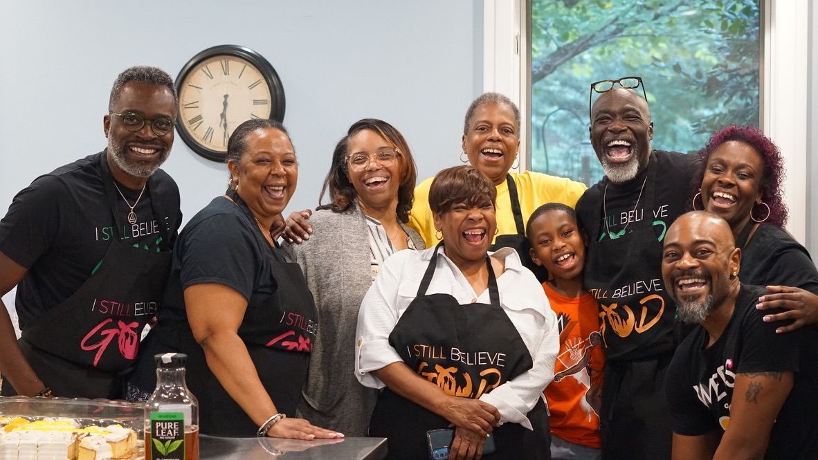 a group of people are posing for a picture in front of a clock .