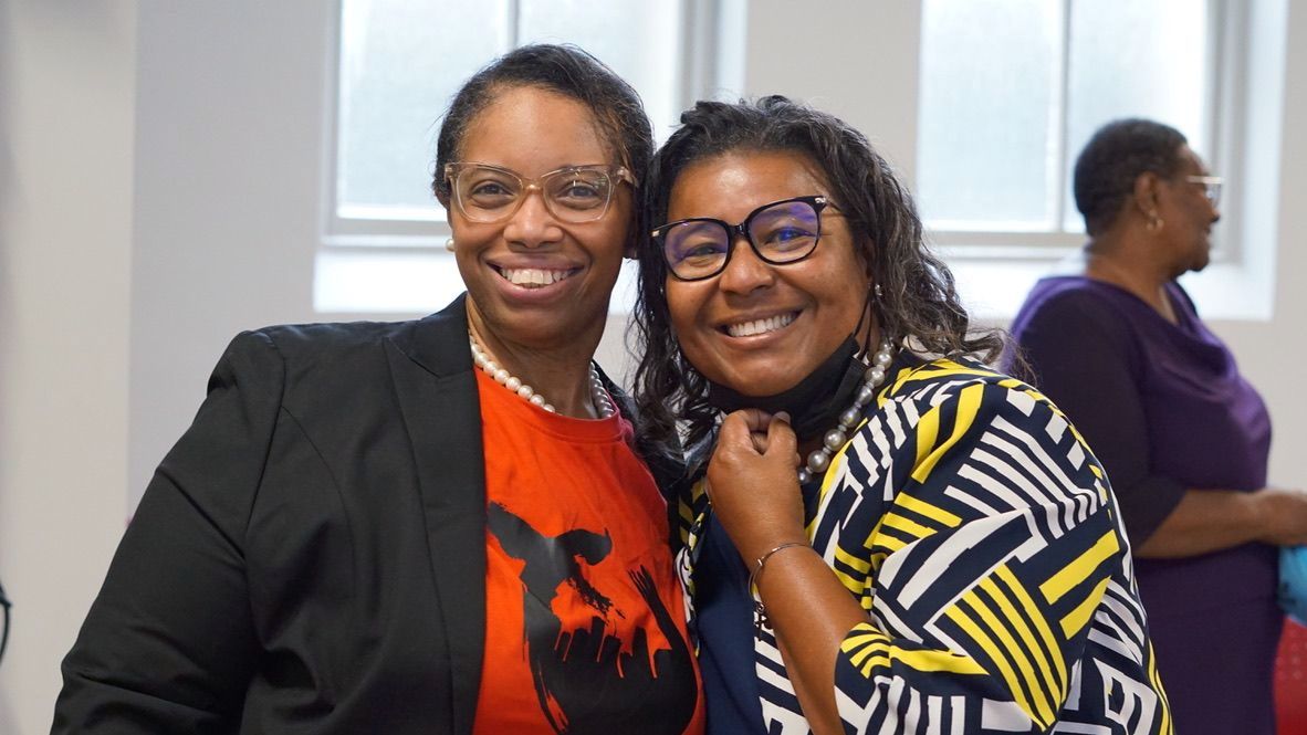 two women are posing for a picture together and smiling .