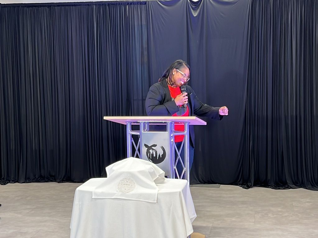 a woman is standing at a podium giving a speech .