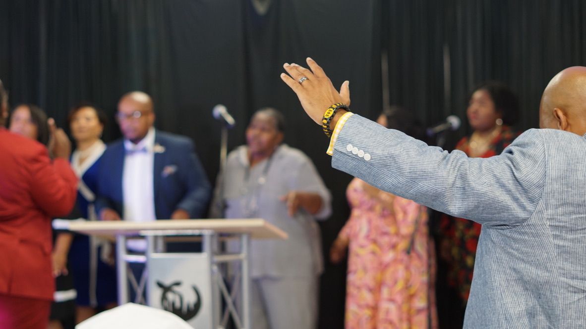 a man in a suit is standing in front of a group of people .