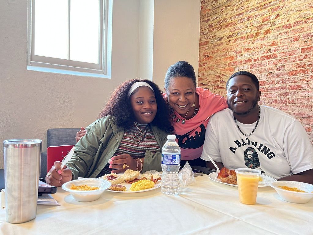 a group of people are sitting at a table eating food .