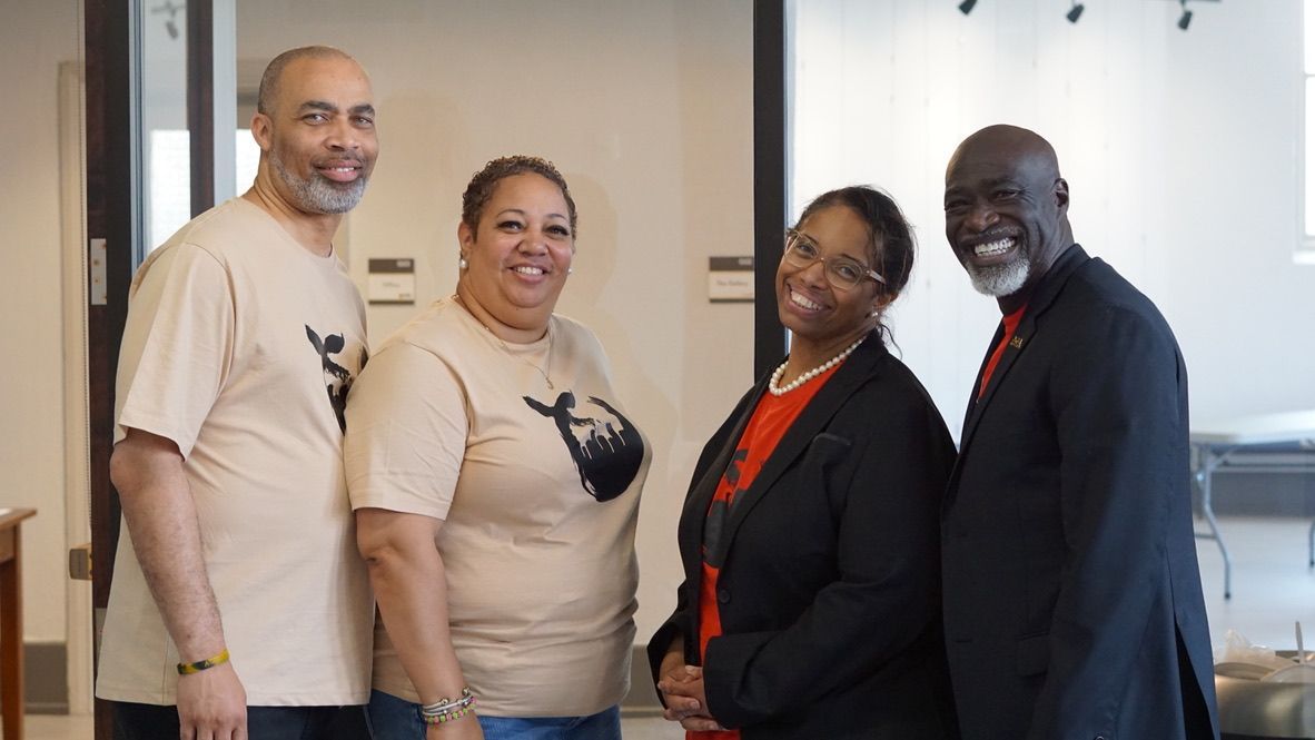 a group of people standing next to each other in a room .