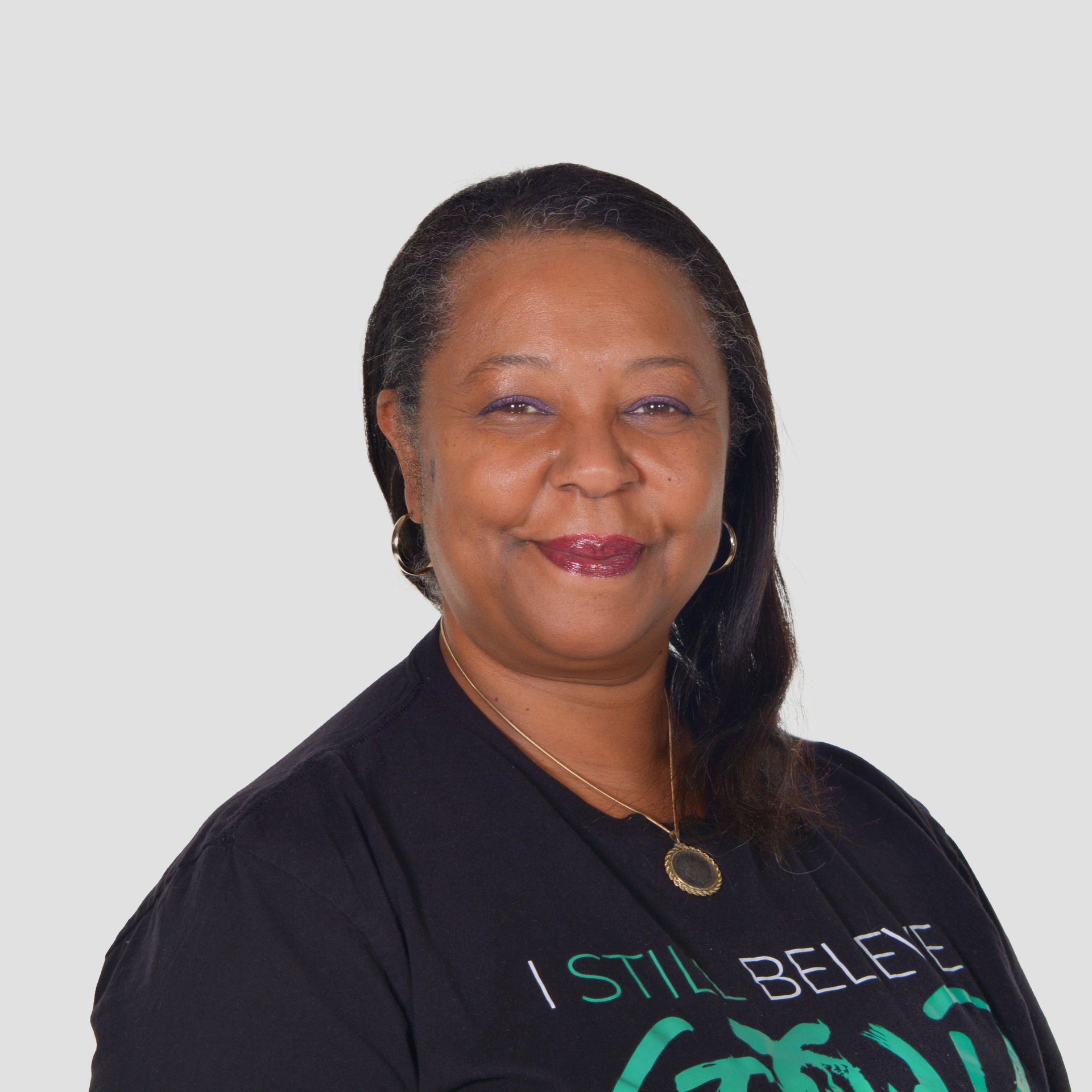 a woman wearing a black shirt that says i still believe