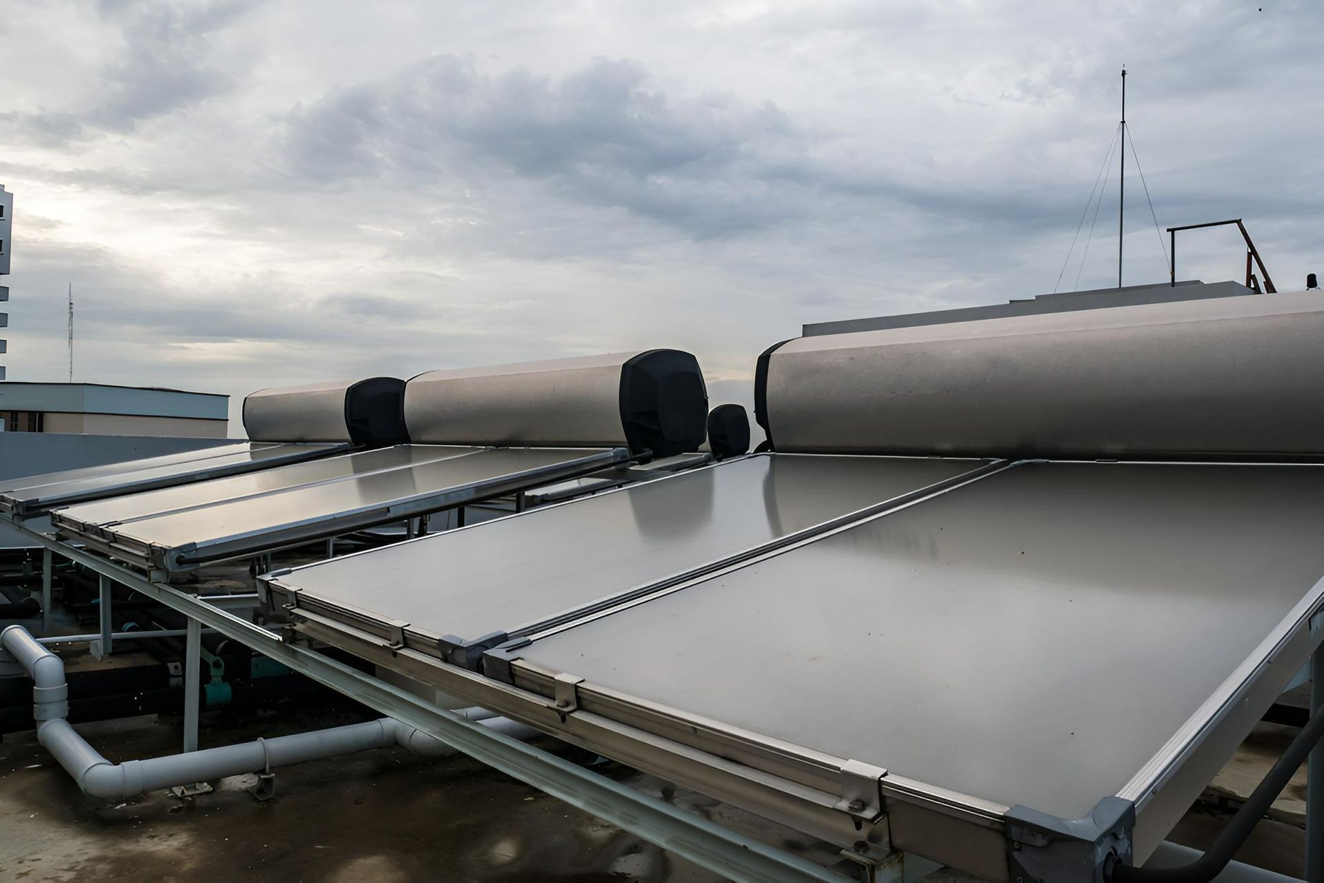 A Row of Solar Panels on the Roof of a Building — Vision Plumbing Queensland in Pimlico, QLD