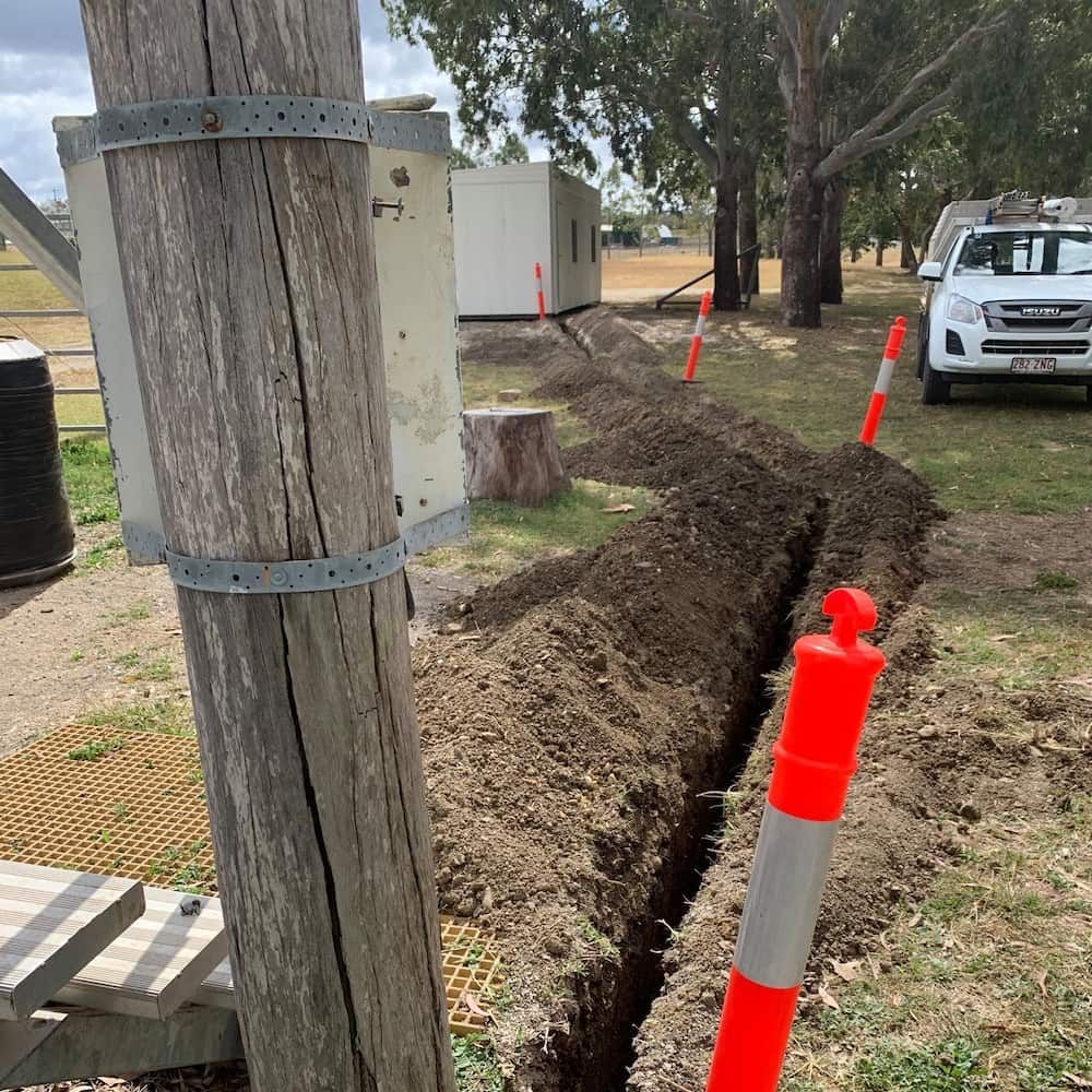 A White Truck is Parked Next to a Wooden Pole in the Dirt — Central Electrical Group in Gladstone Central, QLD