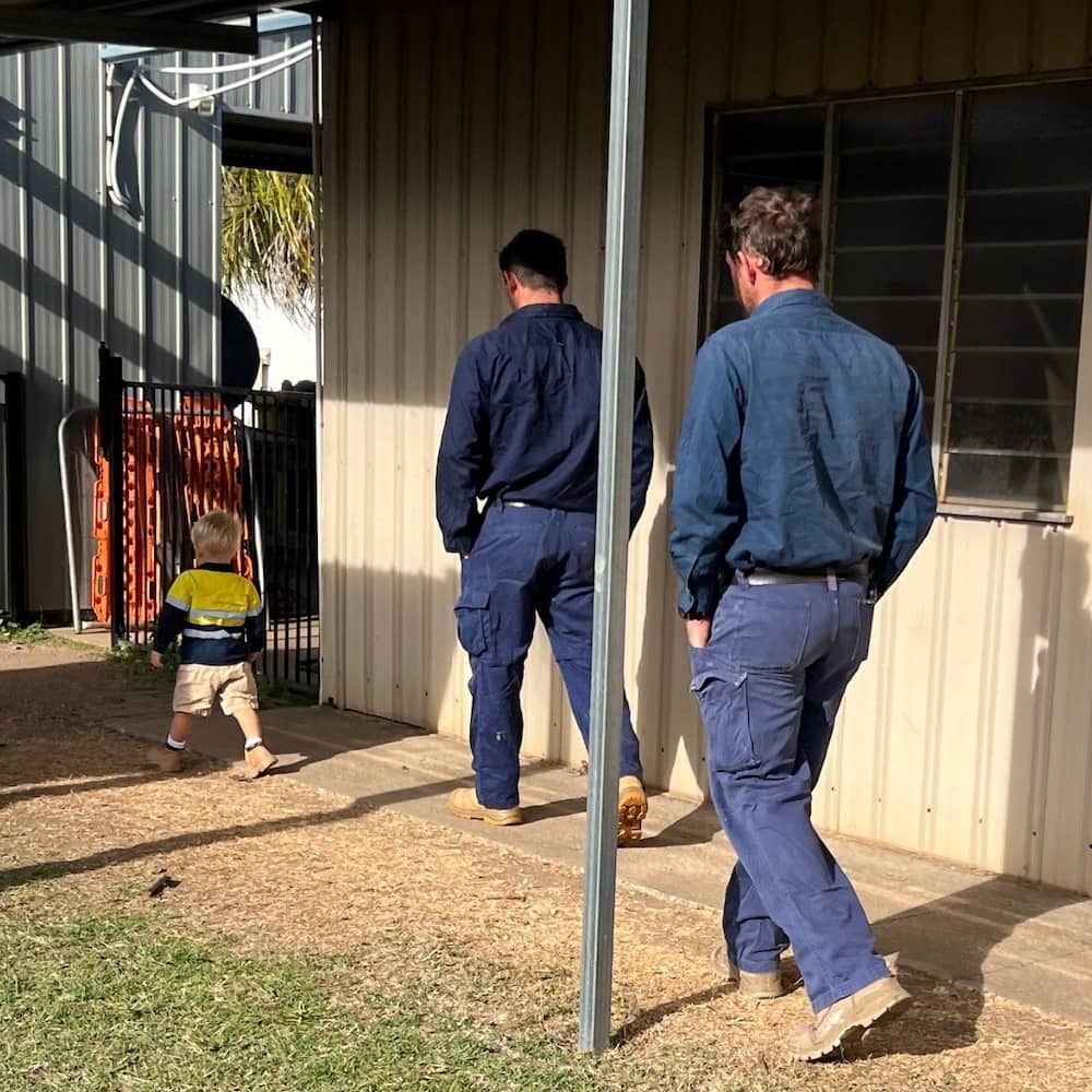 Two Men and a Little Boy Are Walking in Front of a Building — Central Electrical Group in Gladstone Central, QLD