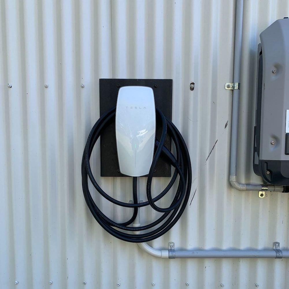 White Tesla Charger Mounted on a Black Square — Central Electrical Group in Rockhampton, QLD