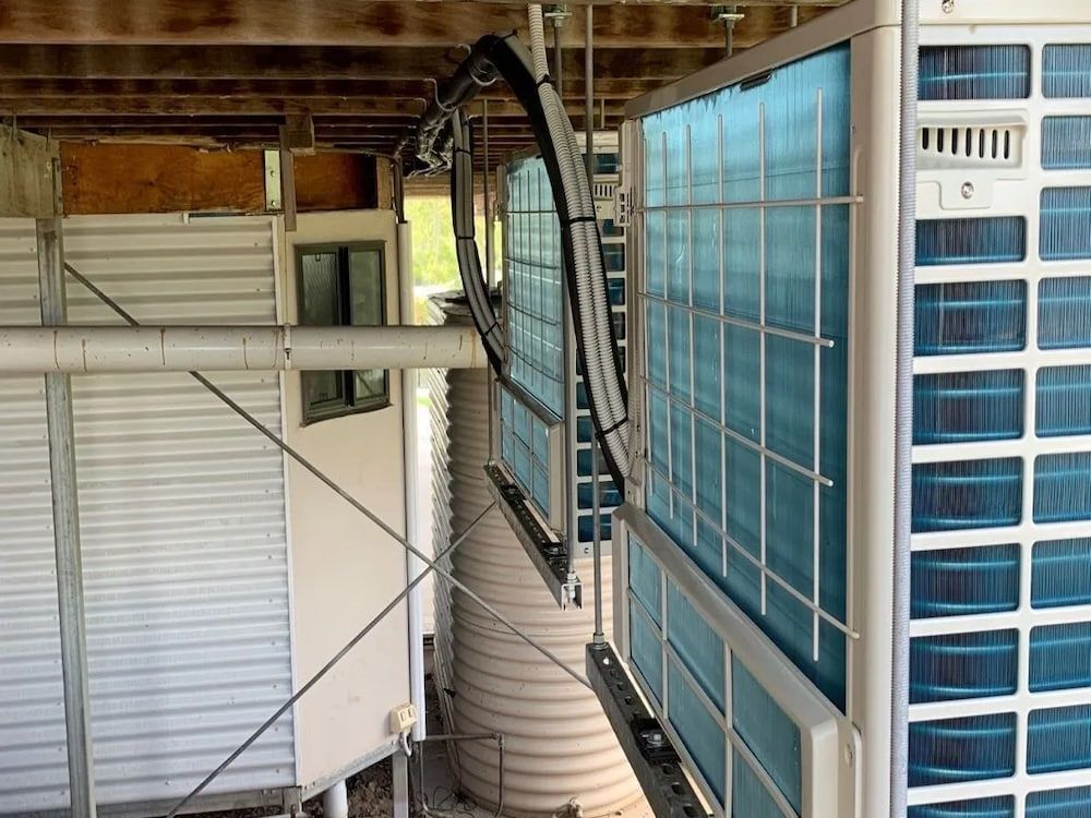 A Large Air Conditioner is Hanging From the Ceiling of a Building — Central Electrical Group in Gladstone Central, QLD