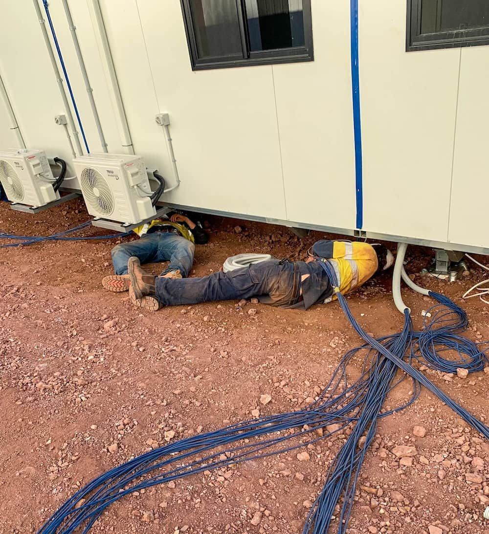 Two Men Checking the Electrical Wires Under the Commercial Building — Central Electrical Group in Gracemere, QLD
