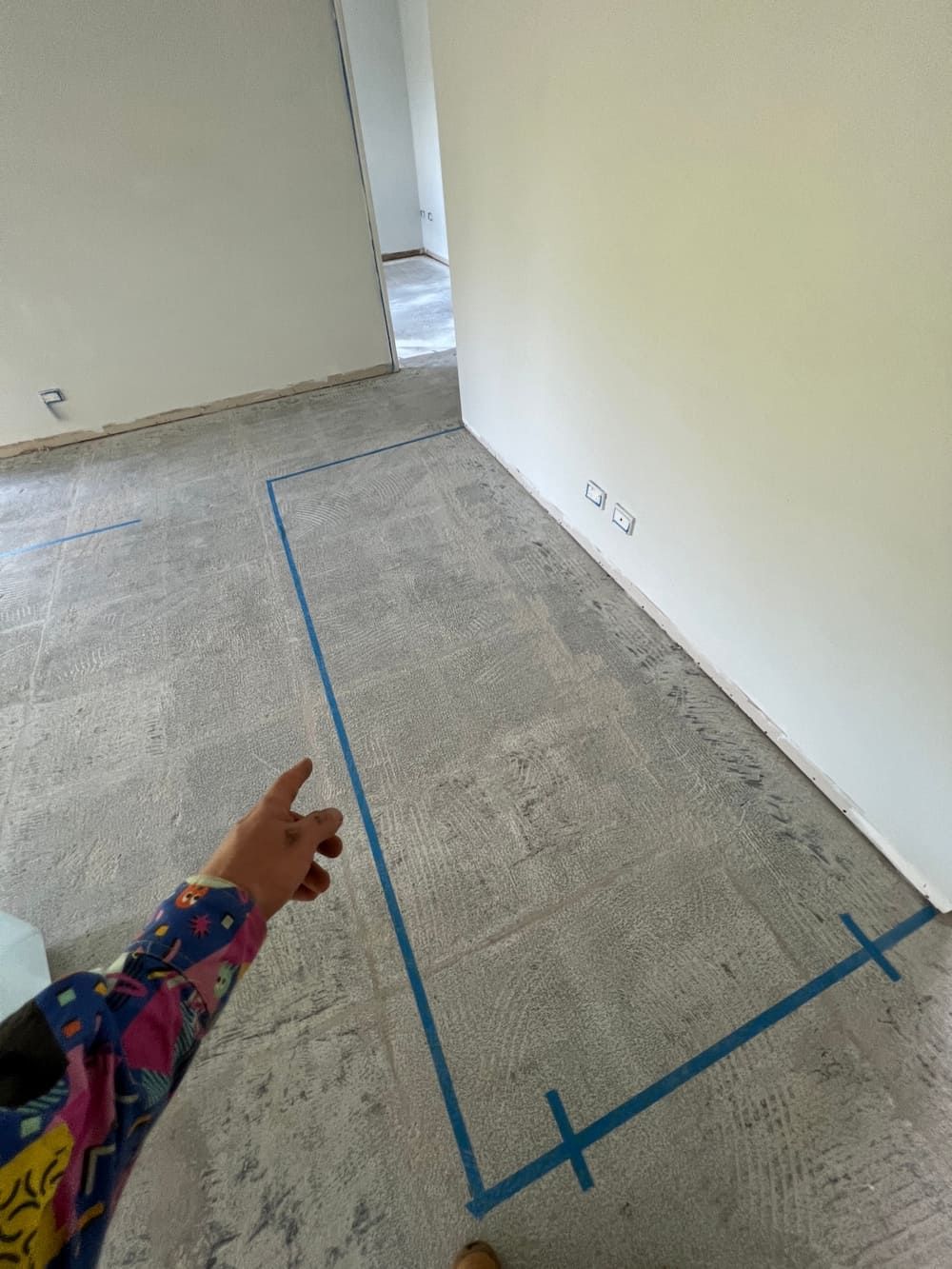 A Person is Pointing at a Blue Tape on the Floor — Central Electrical Group in Gladstone Central, QLD
