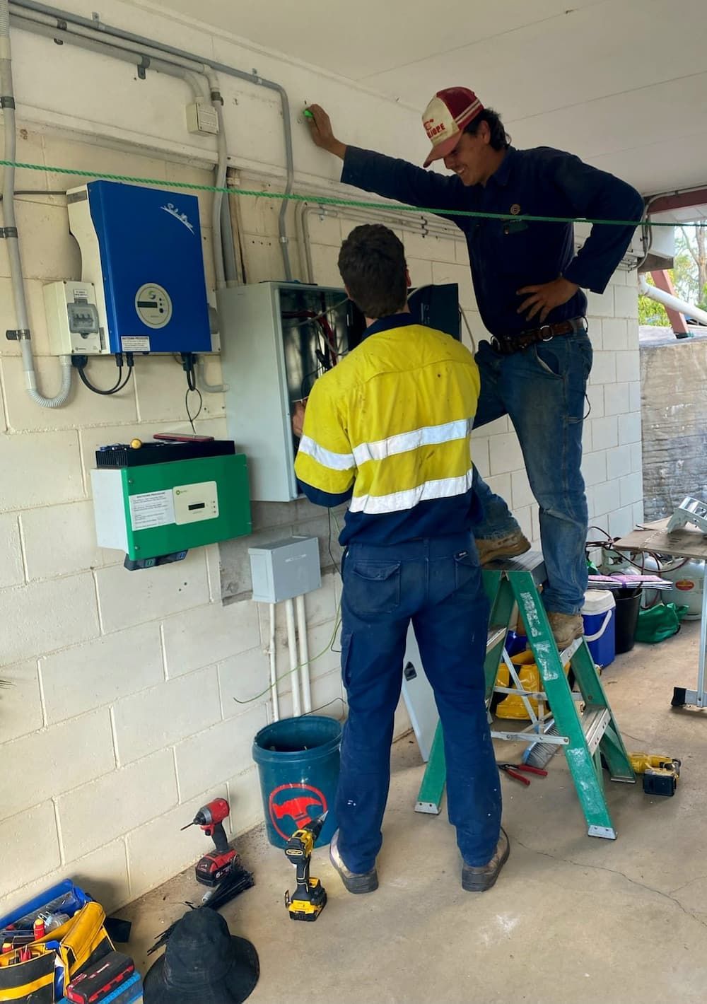 Two Men Are Working on a Solar Panel in a Room — Central Electrical Group in Gladstone Central, QLD